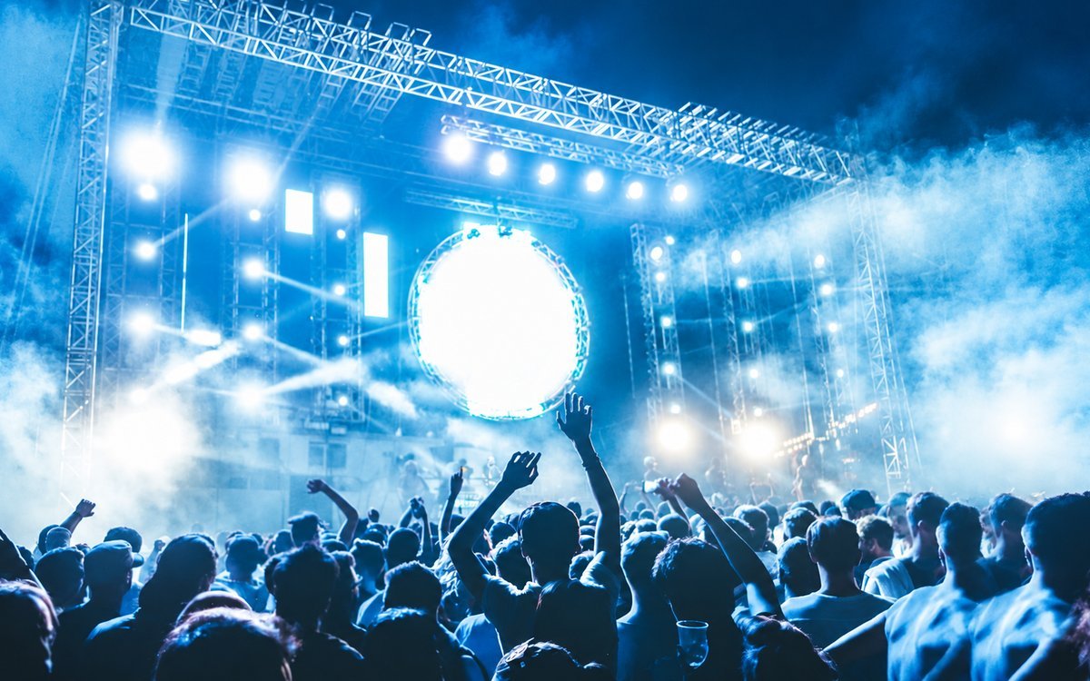 Publikum vor einer beleuchteten Festivalbühne am Abend